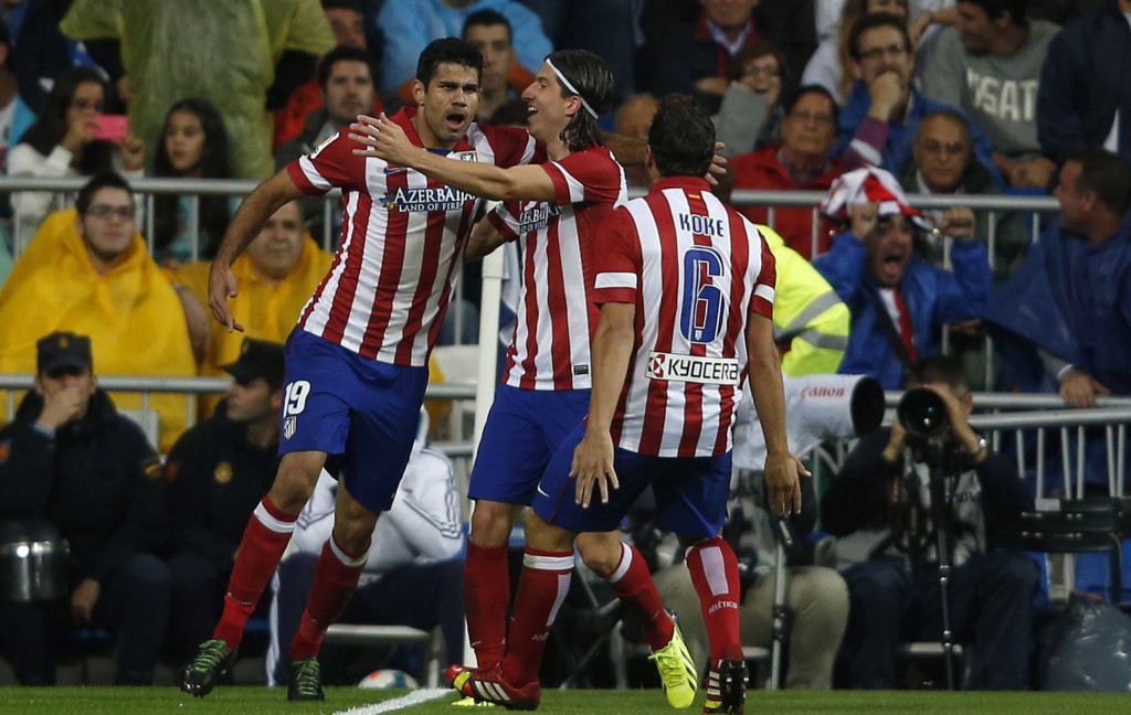 Atletico Madrid's Diego Costa celebrates a goal with teammates Filipe and Koke during the Spanish first division soccer match against Real Madrid at Santiago Bernabeu stadium in Madrid