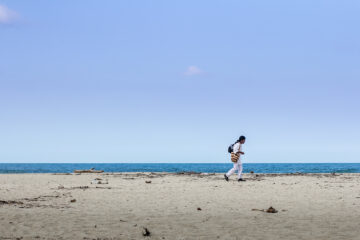 Ένας ιθαγενής περπατάει κατά μήκος της θάλασσας με την κολομβιανή παραδοσιακή τσάντα “mochila” κρεμασμένη στον ώμο.
